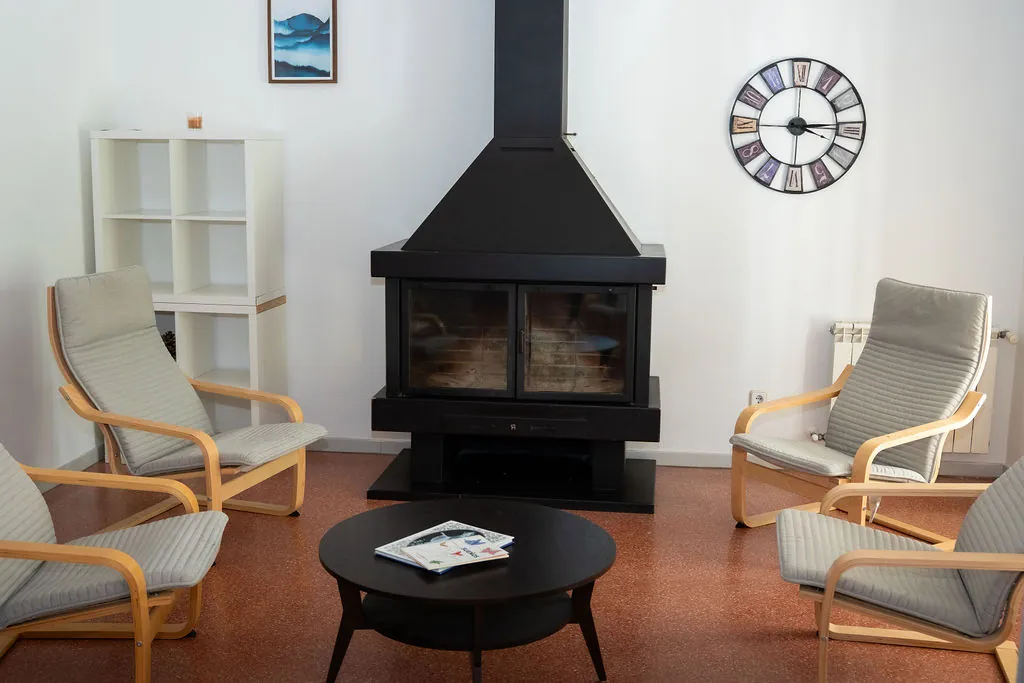 Sala interior con chimenea y sillones para conversar